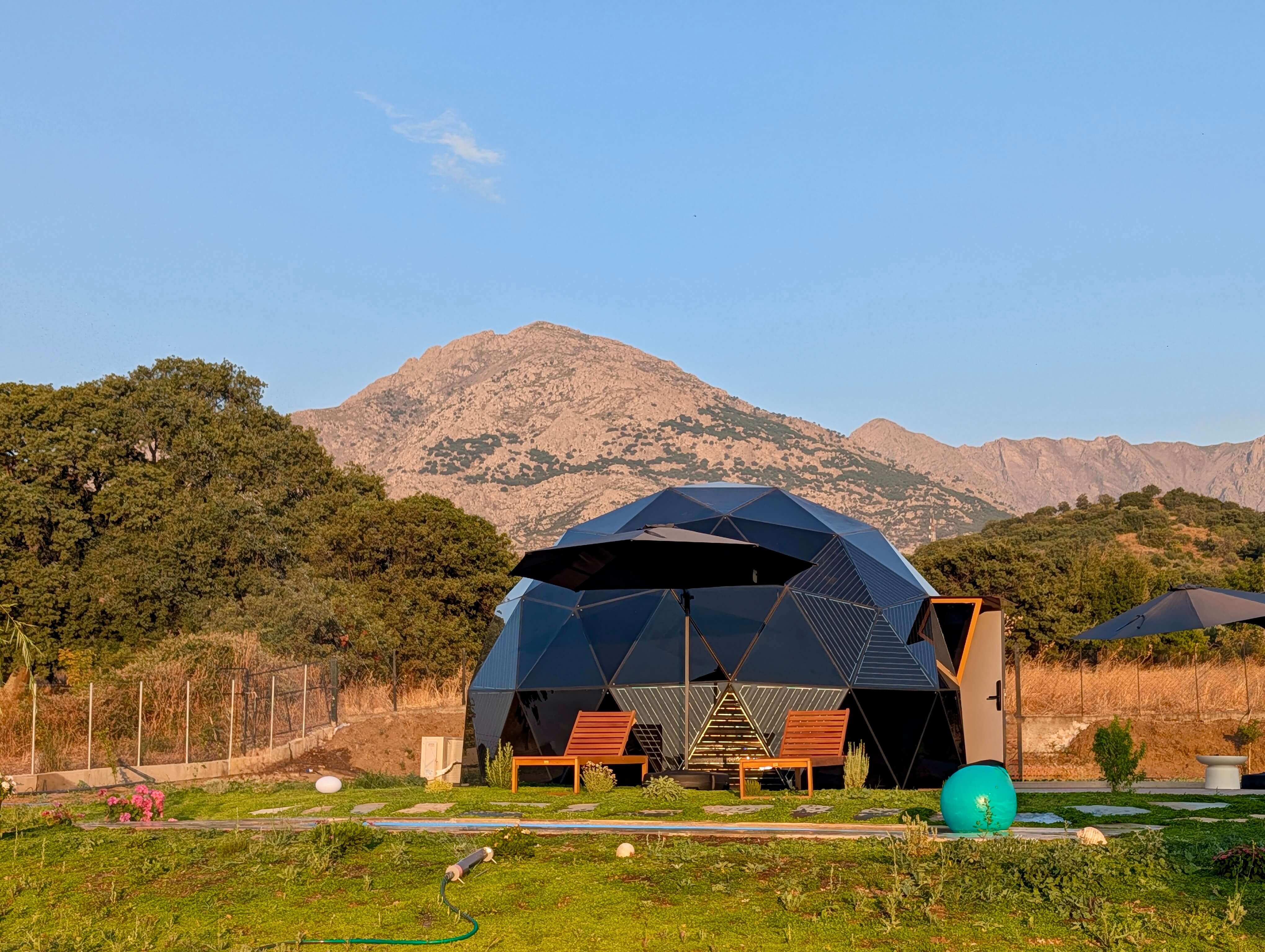 Solar Dome Retreat glass dome at dusk with Mount Fengari rising behind it, Potamia, Samothraki
